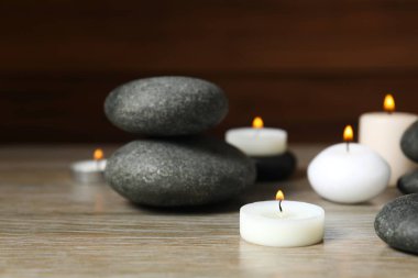 Beautiful composition with burning wax candles and eucalyptus on the table