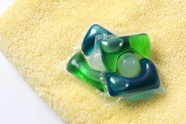 Havluda yıkama kapsülleri. Çamaşır makinesinde çamaşır yıkamak için sıvı tozlu kapsüller.. 