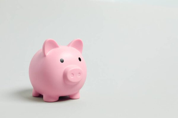 Piggy coin bank on color background for money savings, financial security or personal funds concept