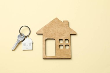 Anahtarlığı olan metal anahtar ve arka planda ahşap ev