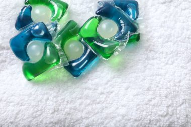 Havluda yıkama kapsülleri. Çamaşır makinesinde çamaşır yıkamak için sıvı tozlu kapsüller.. 