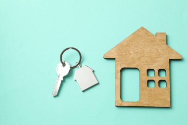 Anahtarlığı olan metal anahtar ve arka planda ahşap ev