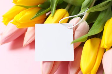 Pastel arka planda bir kartla güzel bir lale buketi. 