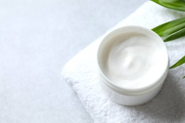 Görünür dokuya sahip açık bir kavanozda sorunlu cilt tipini iyileştirmek için nemlendirici cilt kremi. Palmiye yaprağı dekorasyonu.