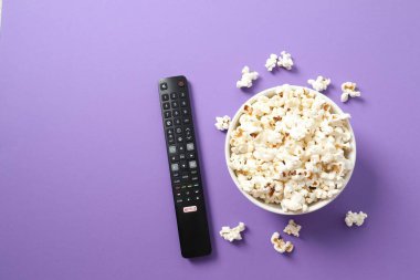 Patlamış mısır ve televizyon uzaktan kumandası renk arkaplanında