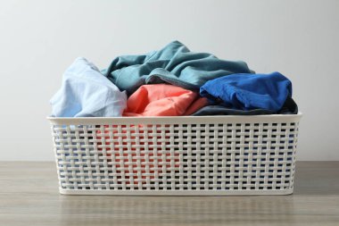 Masadaki çamaşır sepetindeki renkli kıyafetler.