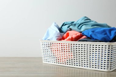 Masadaki çamaşır sepetindeki renkli kıyafetler.