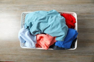 Masadaki çamaşır sepetindeki renkli kıyafetler.