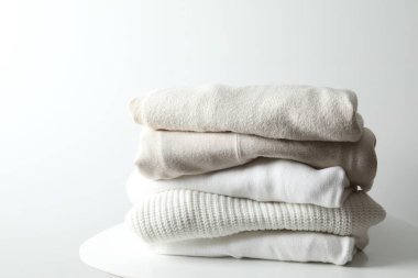 Bir yığın yeni yıkanmış, ahşap bir masanın üzerinde düzgünce katlanmış kıyafet.