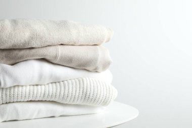 Bir yığın yeni yıkanmış, ahşap bir masanın üzerinde düzgünce katlanmış kıyafet.