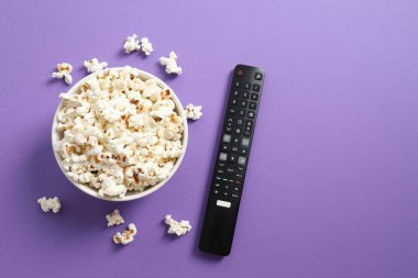 Patlamış mısır ve televizyon uzaktan kumandası renk arkaplanında