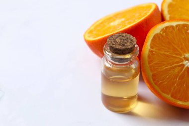 Beyaz arka planda cam bir şişenin içindeki turunçgil yağı. Aromaterapi konsepti. Spa mı? Kozmetik ve vücut bakımı için doğal organik malzemeler