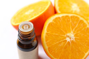 Beyaz arka planda cam bir şişenin içindeki turunçgil yağı. Aromaterapi konsepti. Spa mı? Kozmetik ve vücut bakımı için doğal organik malzemeler