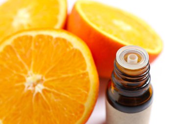 Beyaz arka planda cam bir şişenin içindeki turunçgil yağı. Aromaterapi konsepti. Spa mı? Kozmetik ve vücut bakımı için doğal organik malzemeler