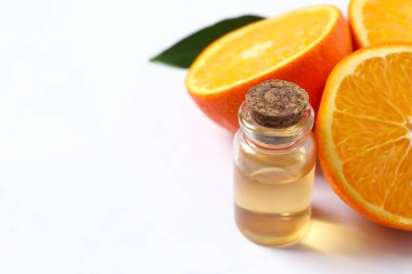 Beyaz arka planda cam bir şişenin içindeki turunçgil yağı. Aromaterapi konsepti. Spa mı? Kozmetik ve vücut bakımı için doğal organik malzemeler