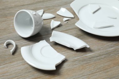 Masada beyaz bardak ve tabak kırılmış.