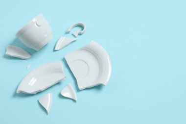 Beyaz fincan ve tabak renk arkaplanda kırılmış. 