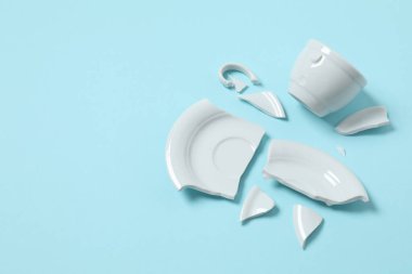 Beyaz fincan ve tabak renk arkaplanda kırılmış. 