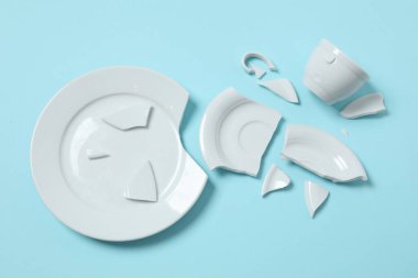 Beyaz fincan ve tabak renk arkaplanda kırılmış. 