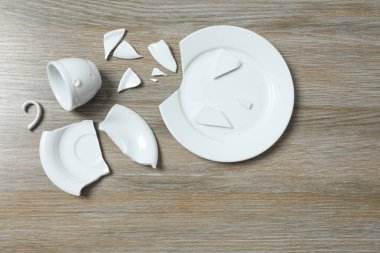 Masada beyaz bardak ve tabak kırılmış.