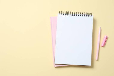 Renk arkaplanında kalem bulunan defterler, üst görünüm