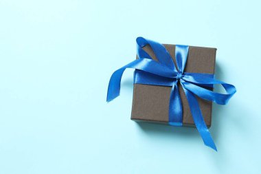 Renk arkaplan üzerinde mavi kurdeleli hediye kutusunun boş arkaplan ile en üstteki görünümü.