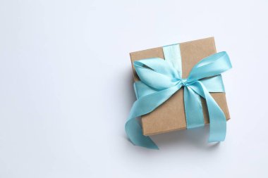 Beyaz arkaplanda kurdele ile hediye kutusunun en üstteki görüntüsü 