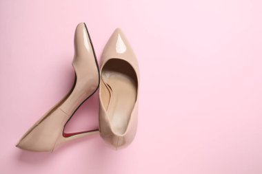 Renkli arka planda klasik kadın bej topuklu ayakkabıları. Üst manzara, düz yatış. Ayakkabı satışı, reklam tasarımı konsepti.