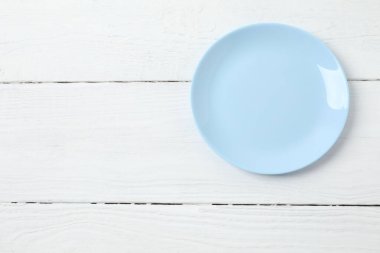 Tahta arka planda boş yuvarlak tabak, üst görünüm