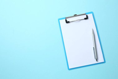 Açık mavi zemin üzerinde kağıt sayfa olan pano, üst görünüm. Metin için boşluk