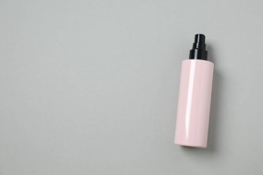 Gri arka planda kozmetik şişesi