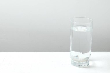 Ahşap bir masanın üzerinde su olan şeffaf cam. Sabahları sağlıklı olmak için temiz su içmek.