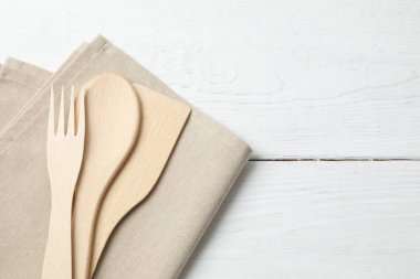 Tahta kesme tahtası, ahşap arka planda mutfak aletleri, üst manzara.