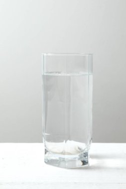 Ahşap bir masanın üzerinde su olan şeffaf cam. Sabahları sağlıklı olmak için temiz su içmek.