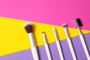 Renkli arka planda kozmetik fırçalar. Makyaj fırçaları.