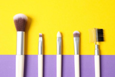 Renkli arka planda kozmetik fırçalar. Makyaj fırçaları.