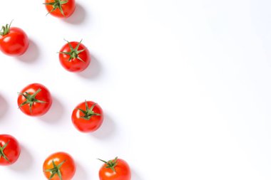 Beyaz arka planda taze vişneli domatesli düz kompozisyon. Olgun sebzeler