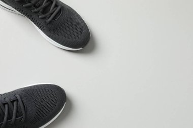 Gri arka planda şık bir çift spor ayakkabı.