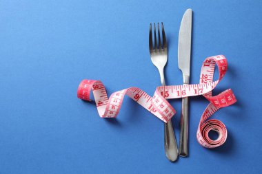 Beyaz arkaplanda çatal bıçak takımı olan kırmızı bant ölçüsü, üst görünüm.