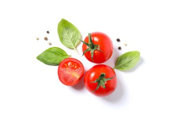 Fesleğenli düz kompozisyon, taze vişneli domates, beyaz arka planda biber. Olgun sebzeler