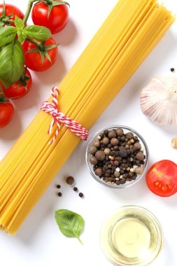 Beyaz arka planda makarna ve yemek malzemeleri ile kompozisyon, üst görünüm