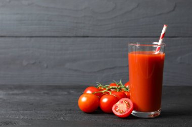 Tomato juice in a glass and fresh tomatoes 