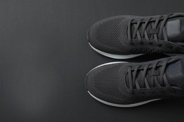 Siyah arka planda şık bir çift spor ayakkabı.