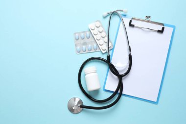 Renk arkaplanında haplı steteskop ve pano, üst görünüm