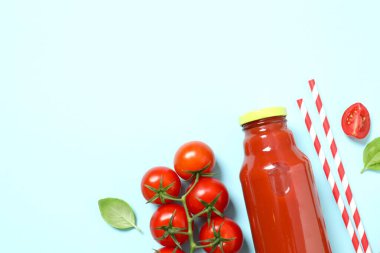 Cam şişede domates suyu ve arka planda taze domates.