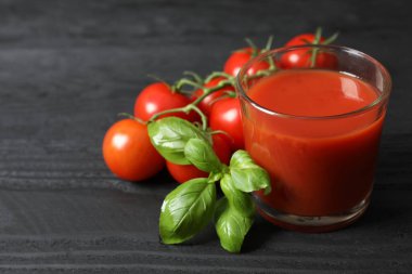 Bardakta domates suyu ve masada taze domates.