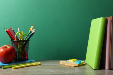 Okula dönelim. Renkli kağıtların, ders kitaplarının, yeşil karatahtanın üzerindeki kırmızı elmanın yakın çekimi