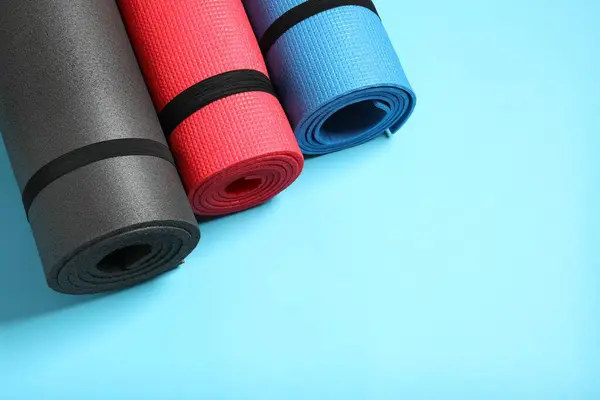 stock image Different mats folded into a roll, karemat for camping, on color background 