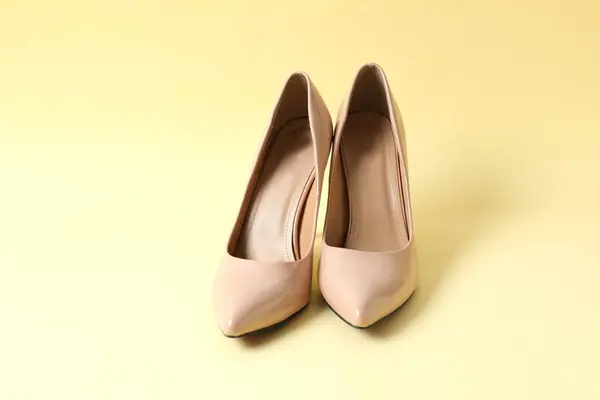 Renkli arka planda klasik kadın bej topuklu ayakkabıları. Üst manzara, düz uzanma