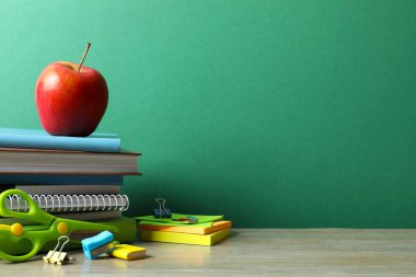 Okula dönelim. Renkli kağıda yakın çekim, yeşil karatahta üzerine ders kitapları